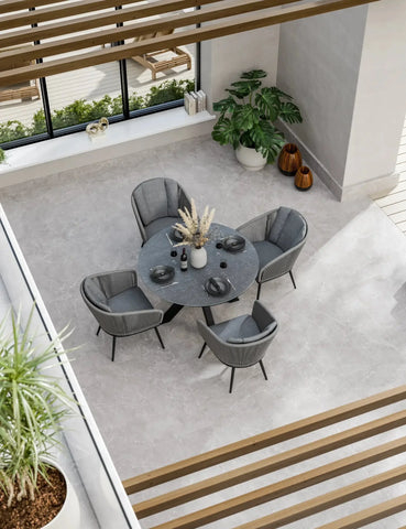 Modern grey dining set with four chairs and round table in bright indoor space