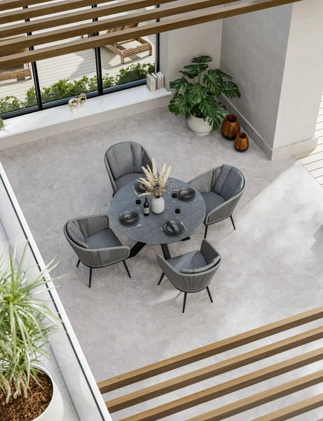 Modern grey dining set with four chairs and round table in bright indoor space