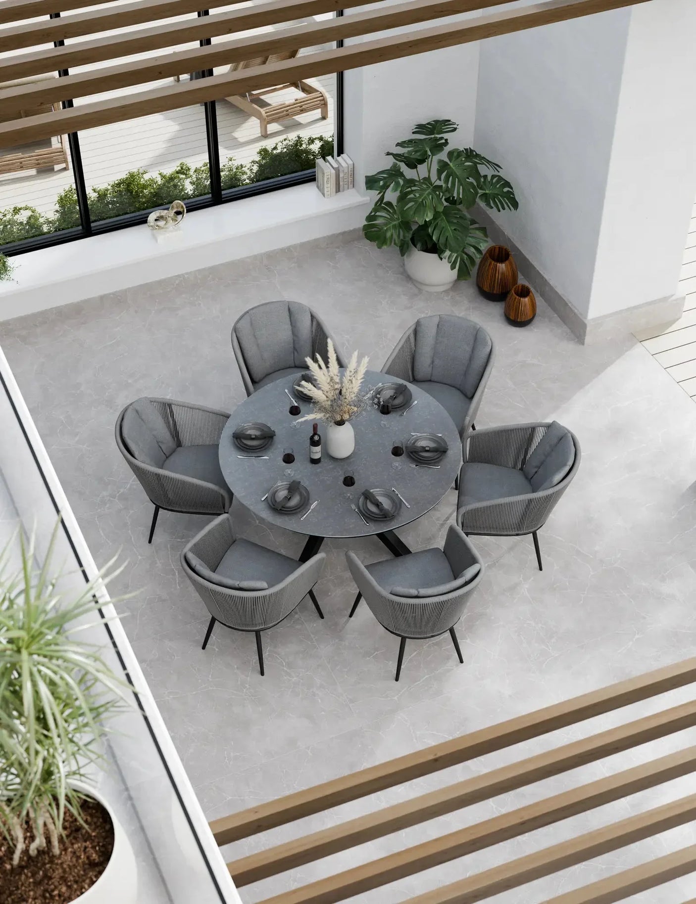 Round grey dining table set with six cushioned chairs in modern indoor setting
