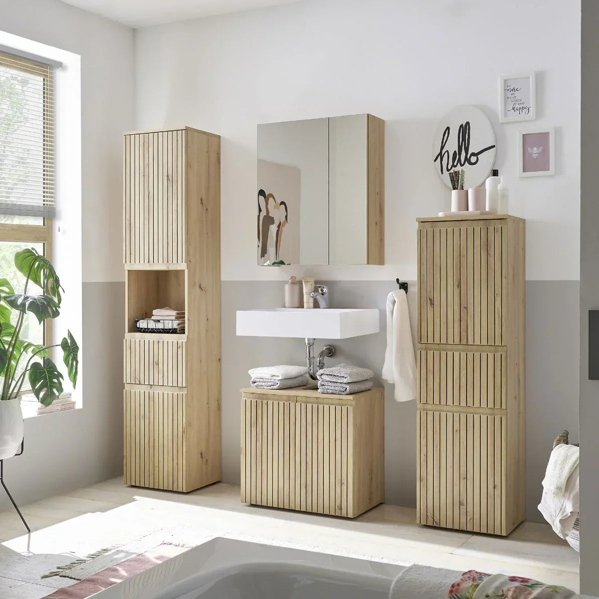 Oak effect bathroom storage cabinets and vanity unit with vertical slat doors in modern setting