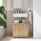 Wooden bathroom vanity unit with slatted doors below white basin and stacked towels