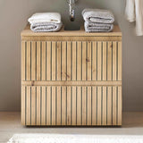 Wood slatted bathroom vanity unit with towels stacked on top under a wall-mounted sink