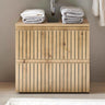 Wood slatted bathroom vanity unit with towels stacked on top under a wall-mounted sink
