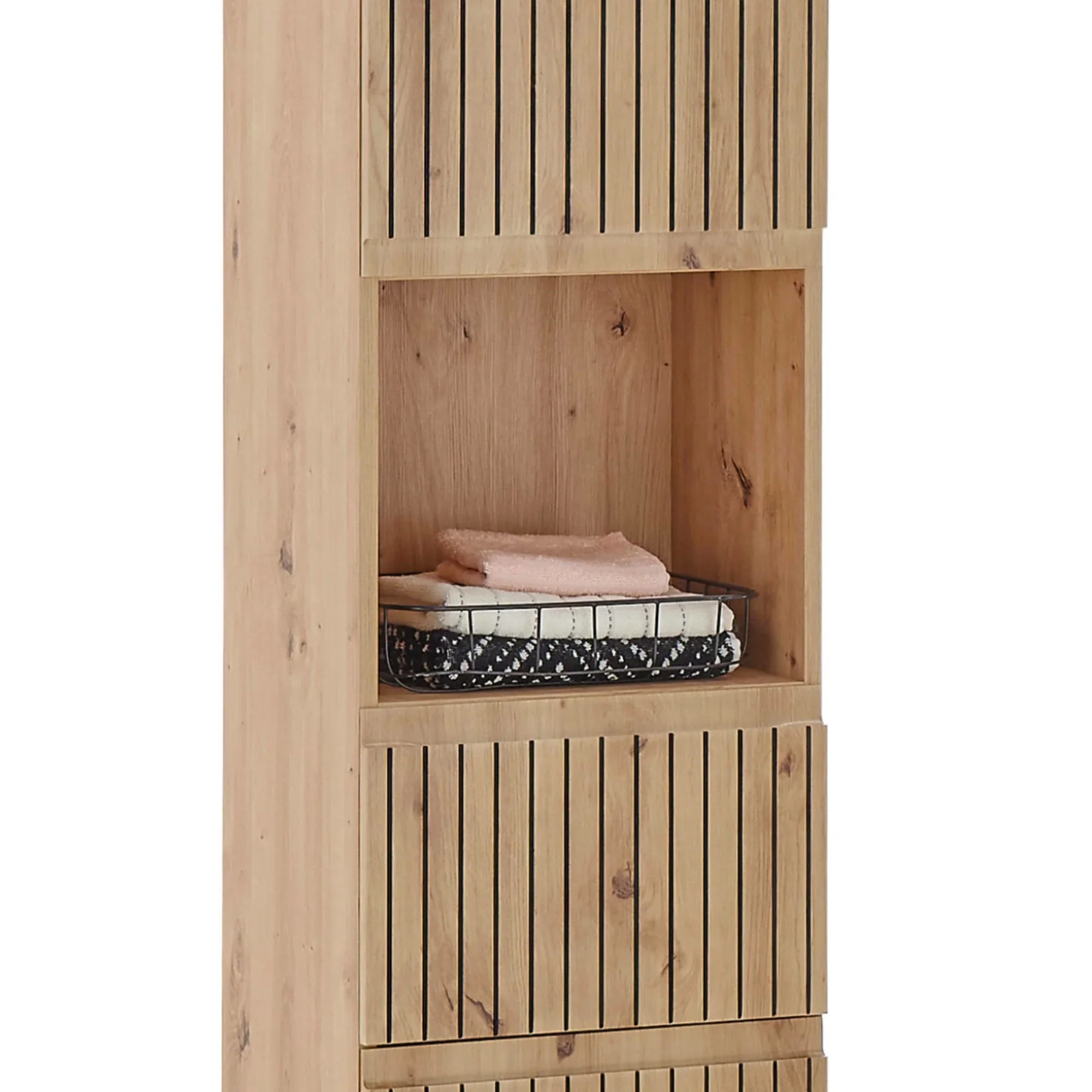 Tall oak storage cabinet with vertical slat doors and open shelf holding folded towels