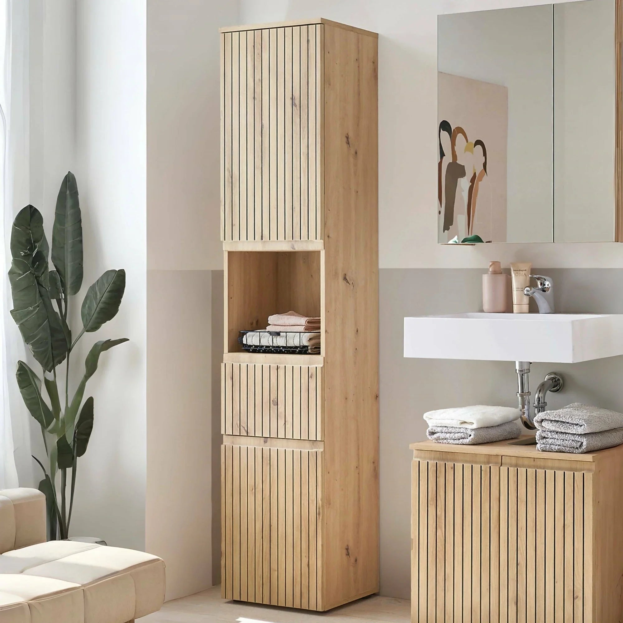 Tall oak bathroom storage cabinet with vertical slats beside sink and folded towels