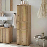 Tall oak bathroom storage cabinet with slatted doors beside sink and matching vanity unit