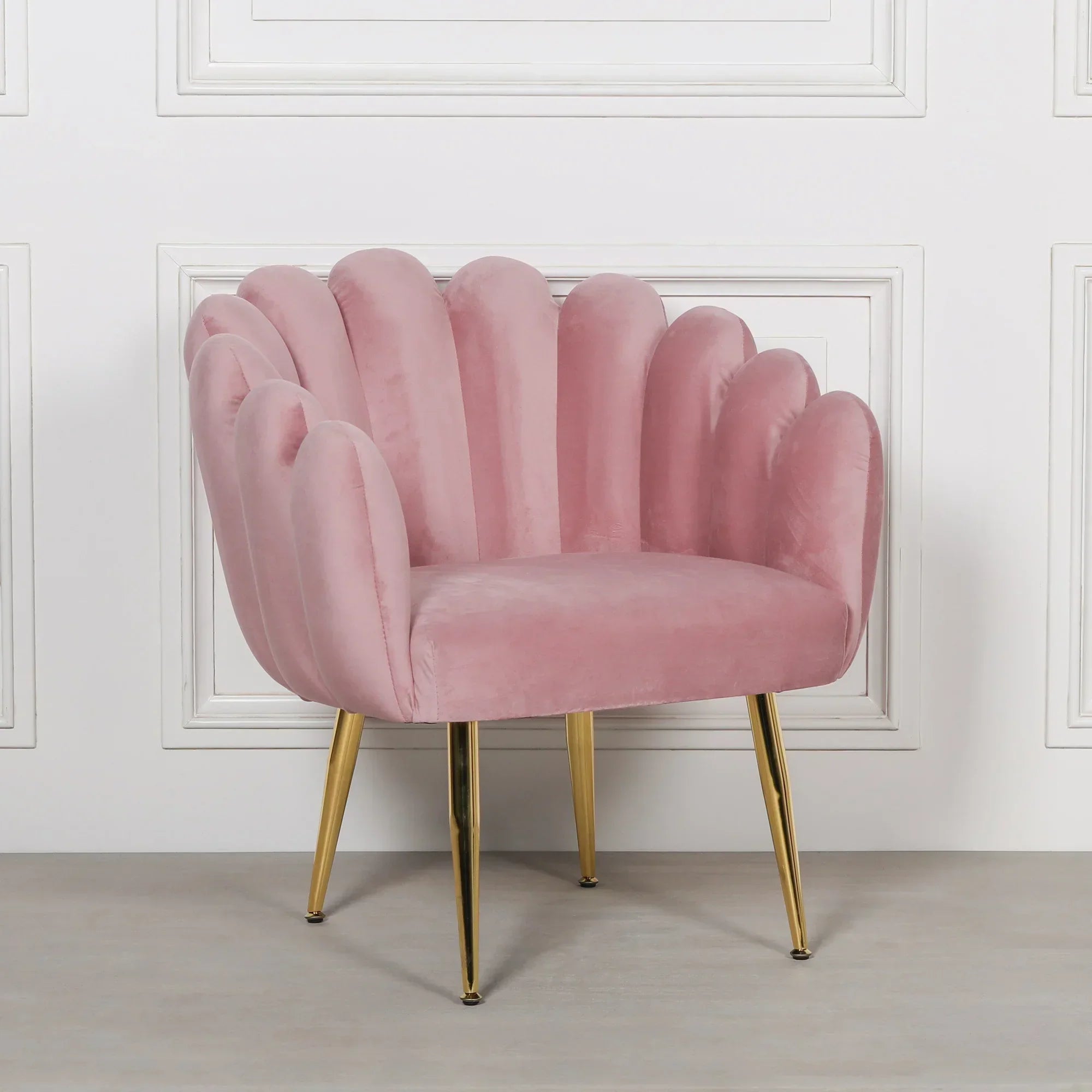 Pink velvet accent chair with scalloped backrest and gold metal legs