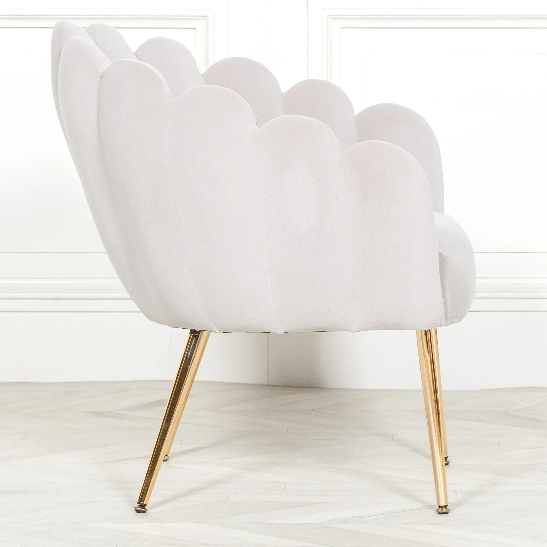 Scalloped shell accent chair with white velvet upholstery and gold metal legs, side angle view