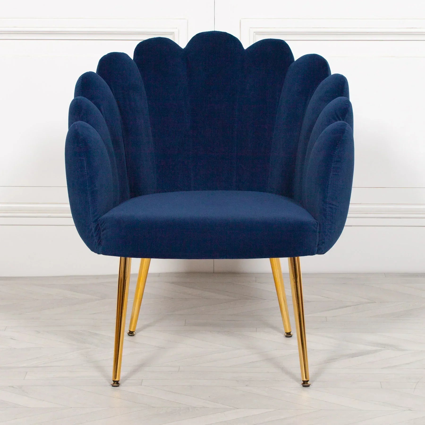 Navy blue velvet accent chair with gold metal legs and scalloped backrest