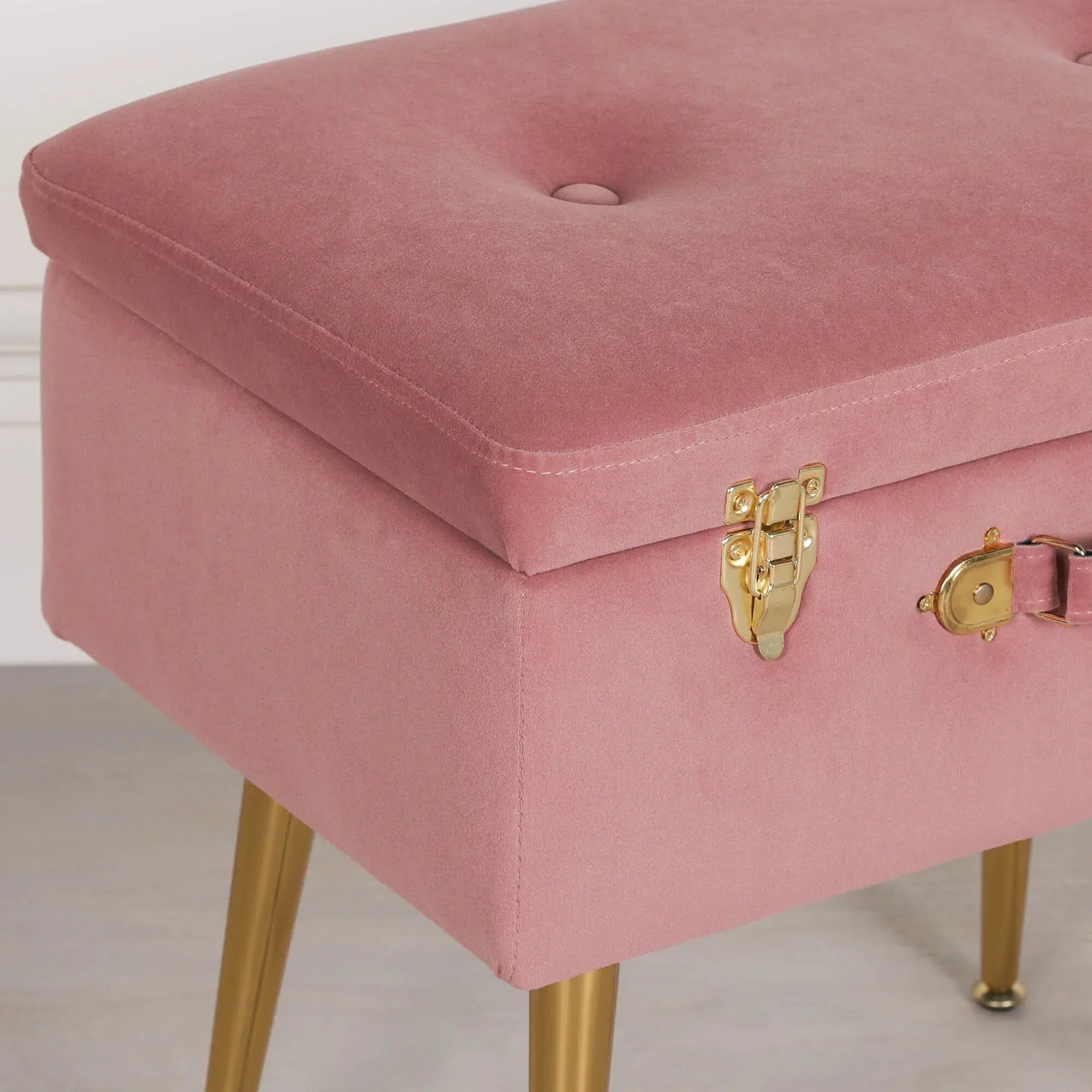 Pink velvet storage bench with gold metal legs and latch close-up