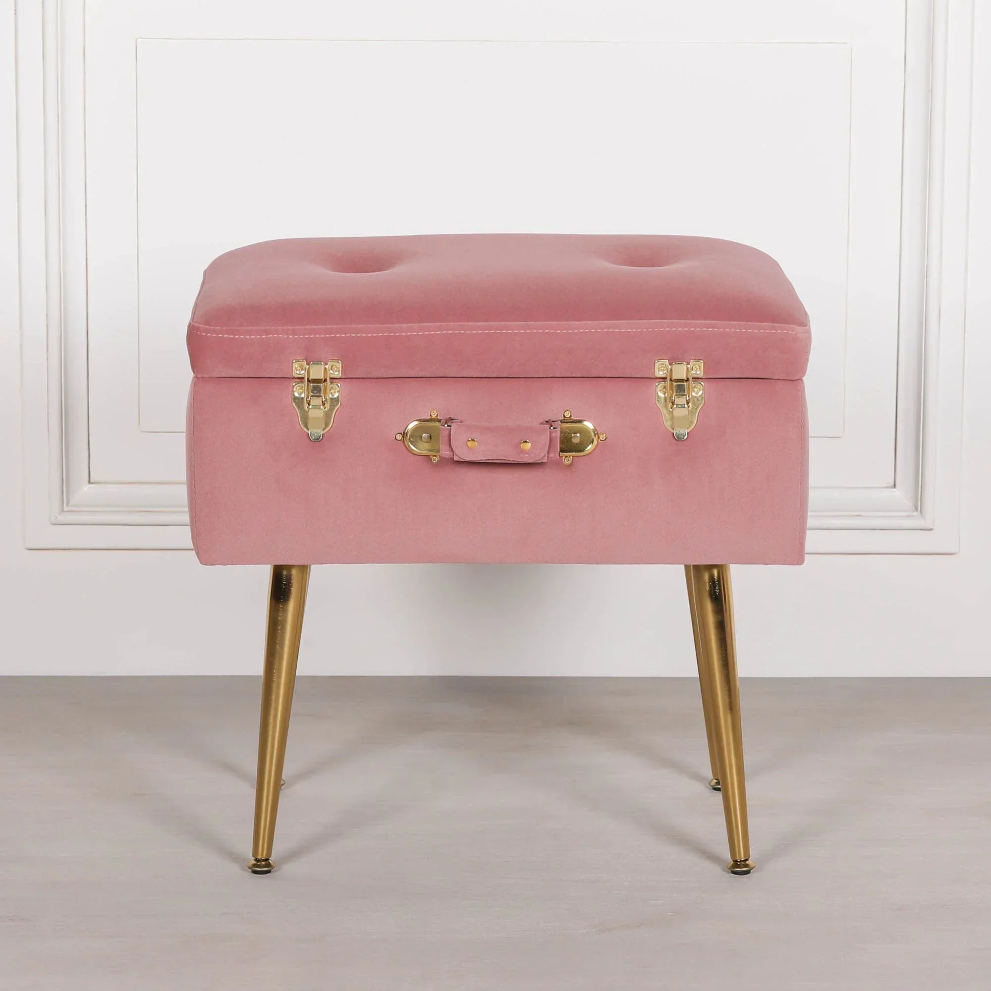 Pink velvet ottoman with gold metal legs and suitcase style latch front view