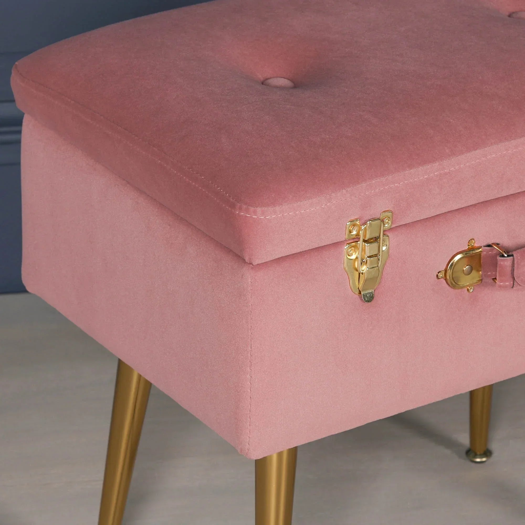 Pink velvet storage bench with gold legs and latch detail