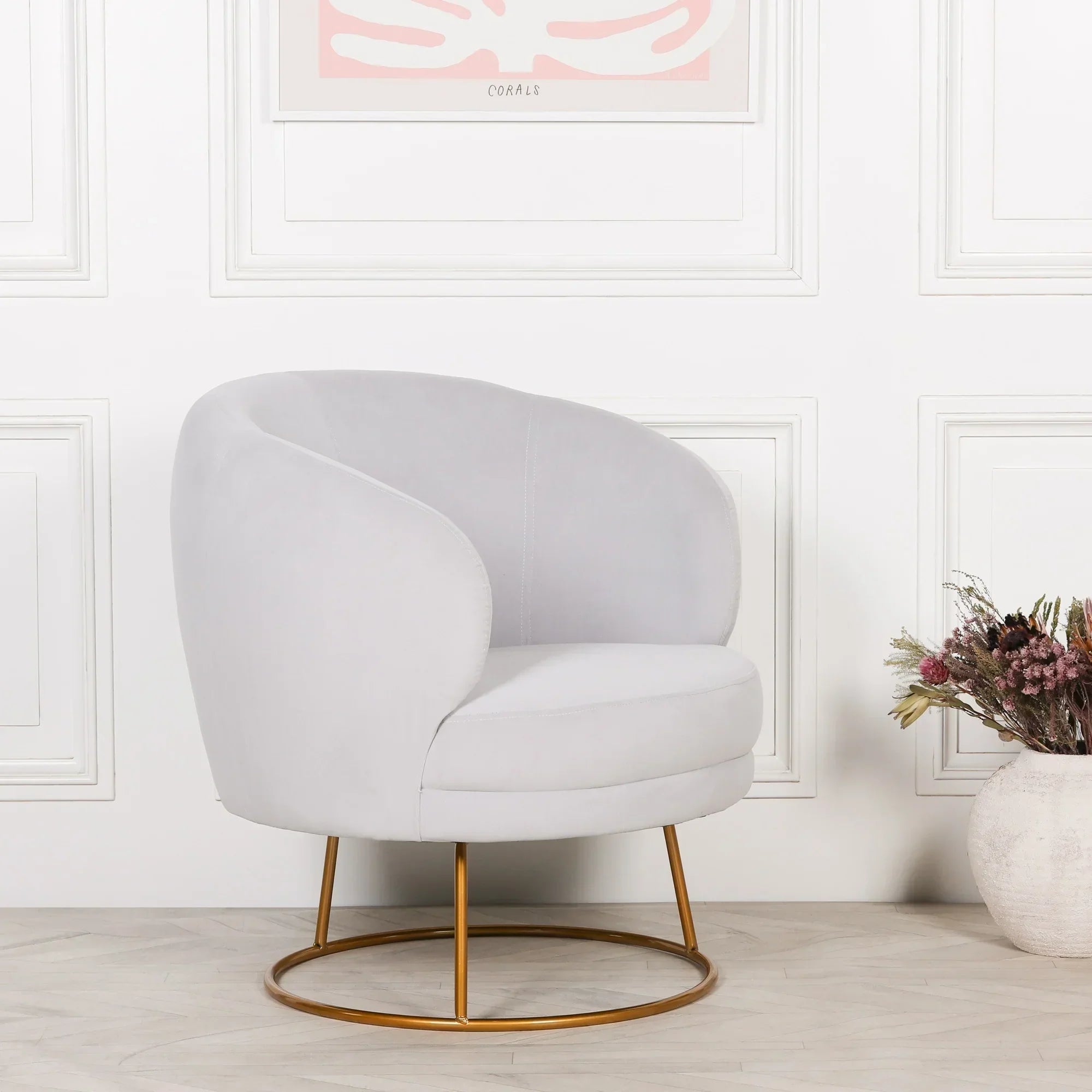 Light grey velvet accent chair with gold metal base in modern living room setting