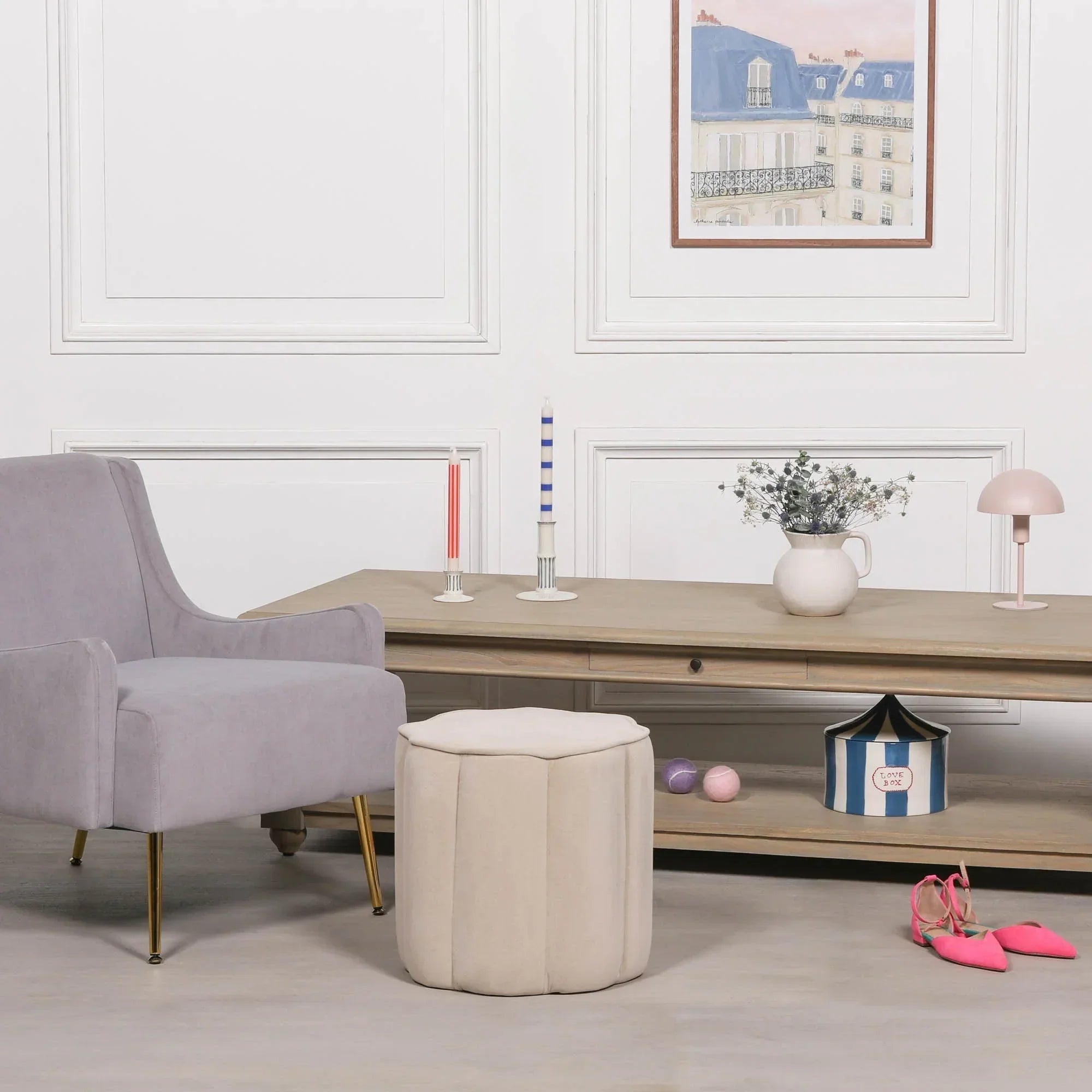 Beige velvet ottoman stool and grey armchair in modern living room with wooden console table