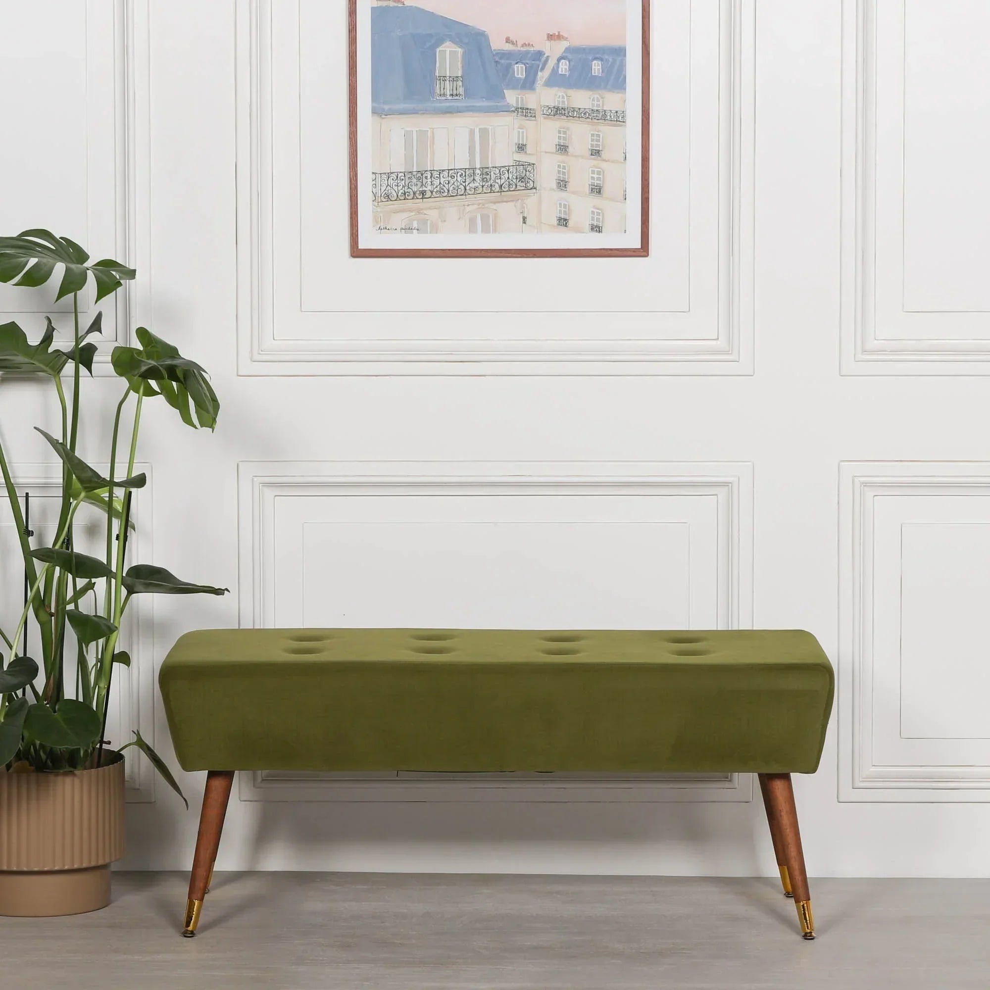 Green velvet bench with wooden legs and gold tips in modern living room setting