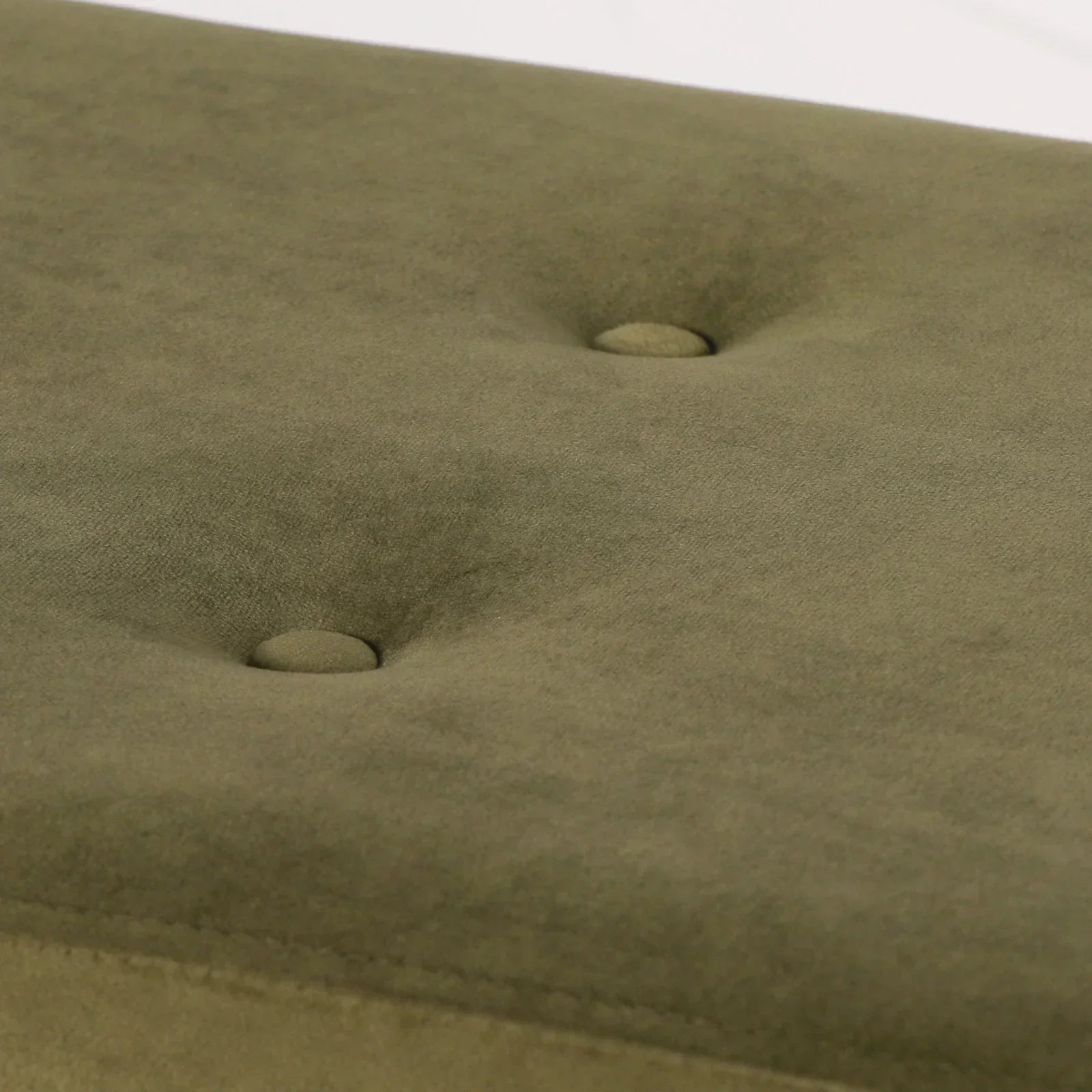 Olive green upholstered furniture seat with button tufting close-up
