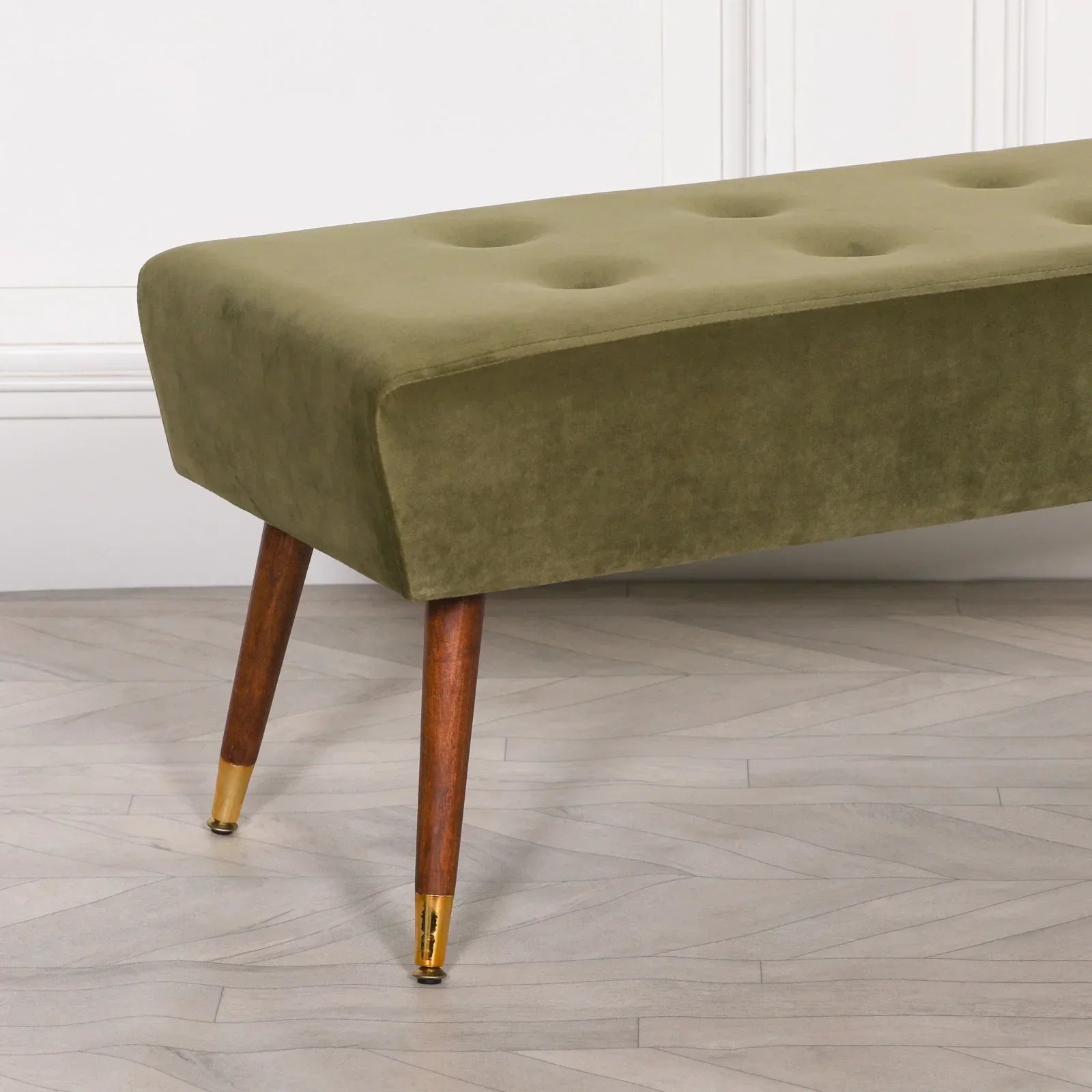 Olive green velvet bench with button tufting and angled wooden legs, gold metal feet