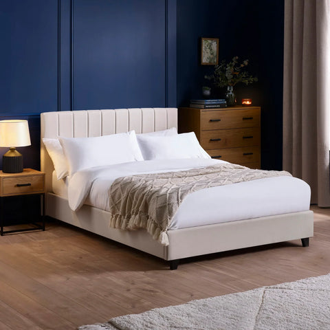 Beige upholstered bed with vertical panel headboard in modern bedroom with wooden furniture