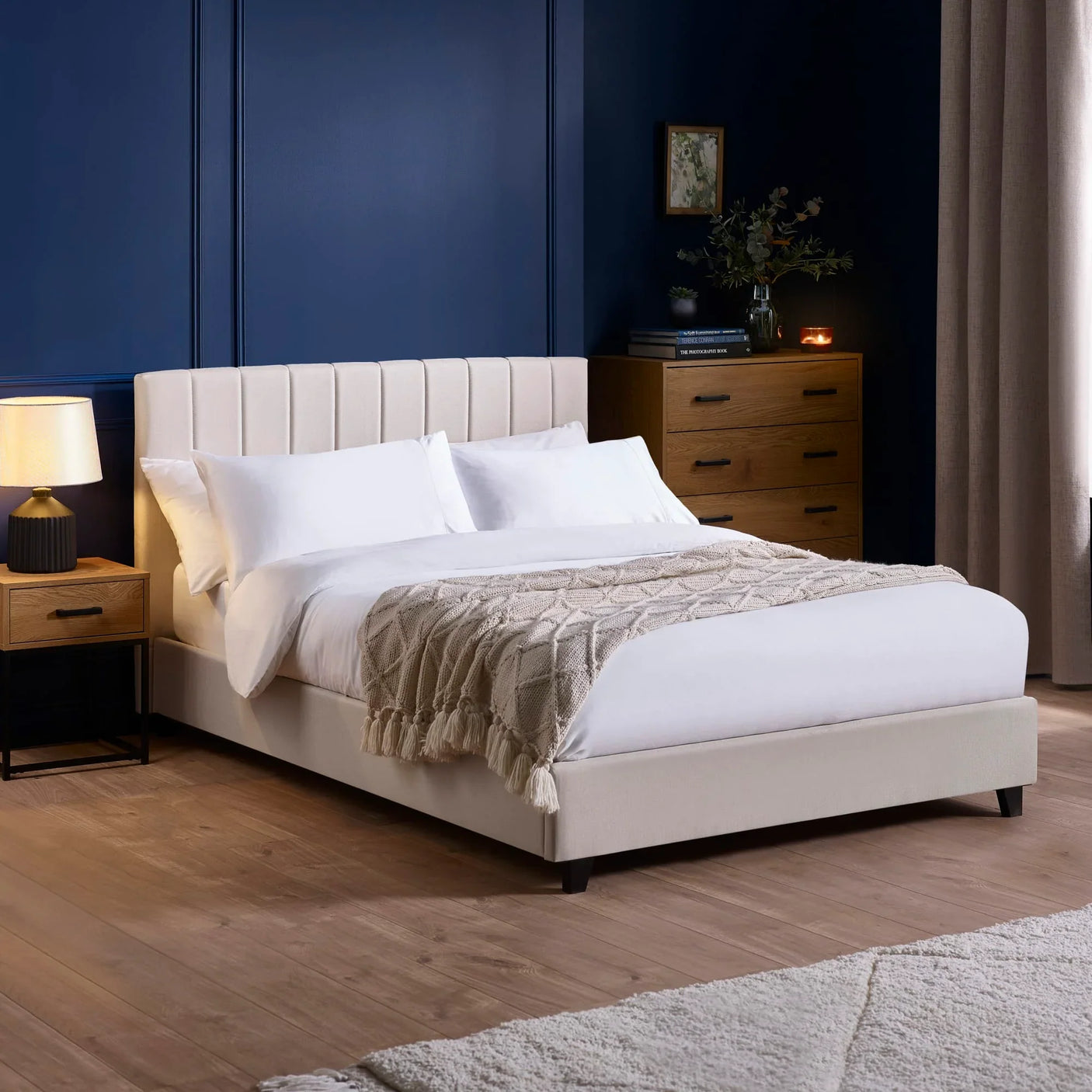 Beige upholstered bed with vertical panel headboard in modern bedroom with wooden furniture
