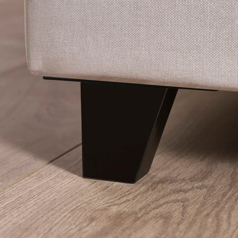 Closeup of fabric sofa corner with black metal leg on light wood floor