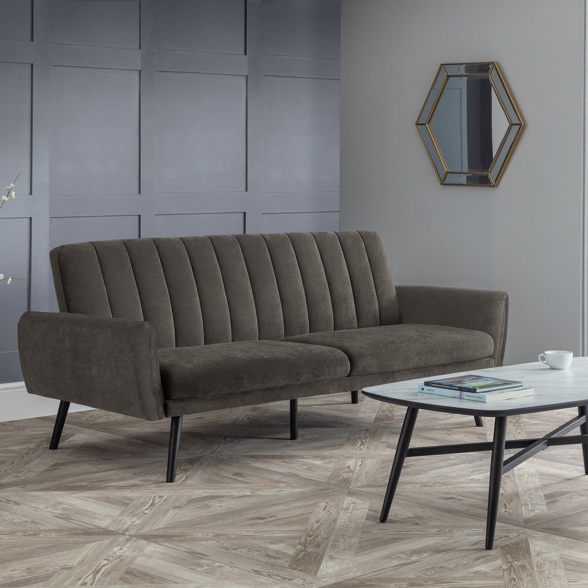 Grey sofabed with vertical stitching and black legs in modern living room setting