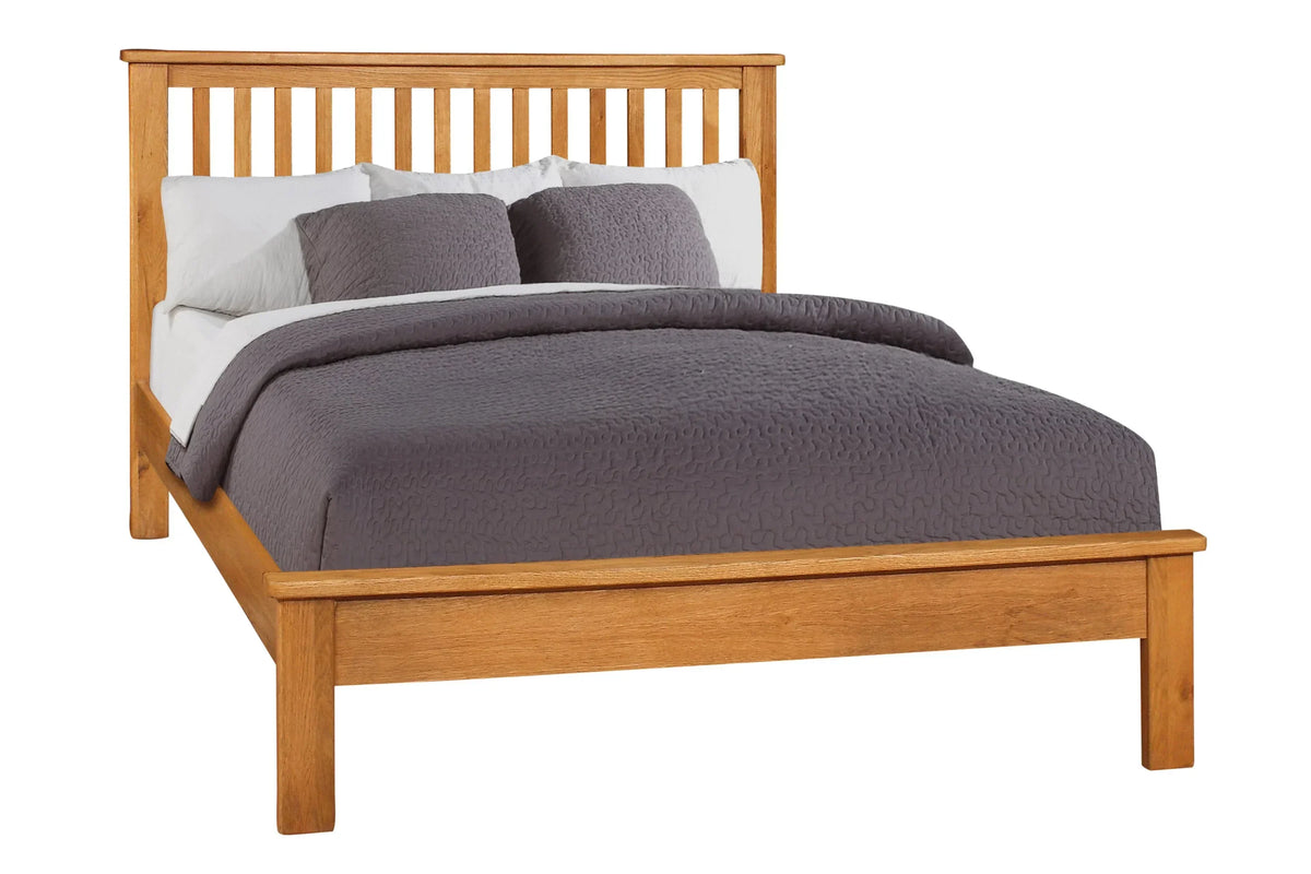 Wooden bed frame with slatted headboard, grey bedding and low foot end, front angle view