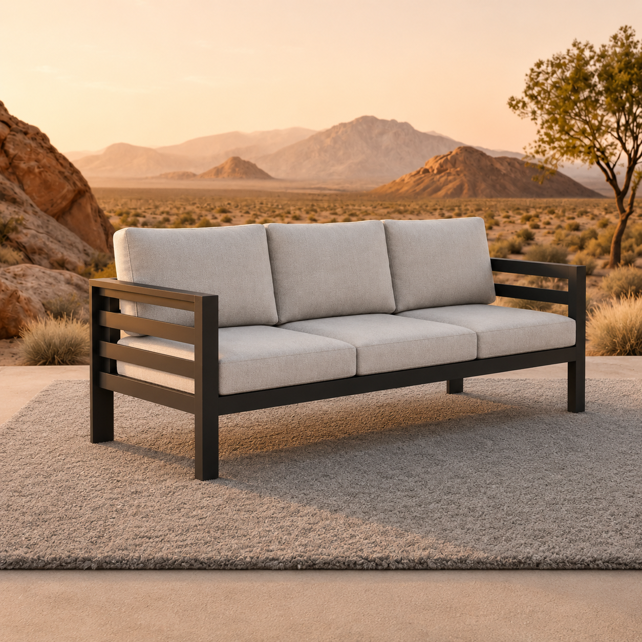 Light grey fabric cushions on a black metal frame sofa placed on a textured rug outdoors.