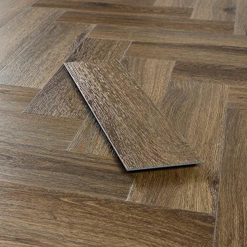 Antique walnut herringbone vinyl flooring sample on wood patterned floor
