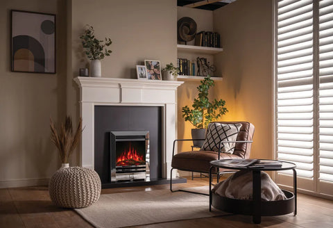 Anya electric fire installed in a modern living room with a stylish armchair and decorative plants.