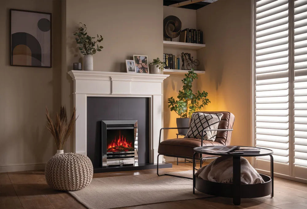 Anya electric fire installed in a modern living room with a stylish armchair and decorative plants.