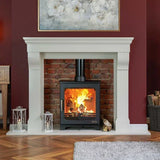 Wood burning stove in white fireplace with brick surround, firewood and lanterns in living room