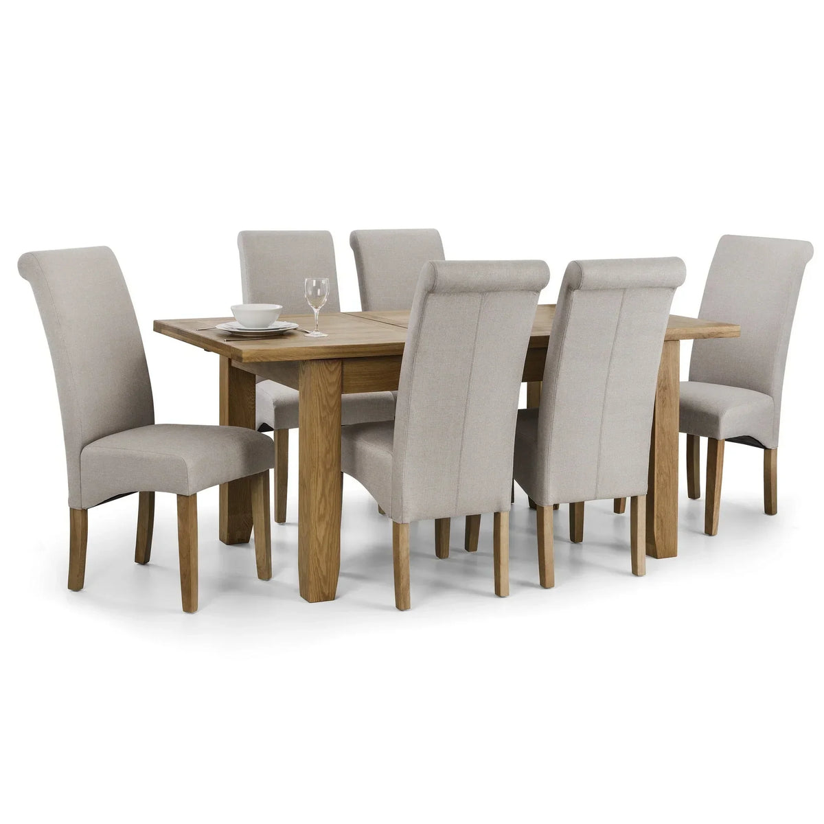 Oak extending dining table with six beige upholstered chairs, set with dishes and glassware