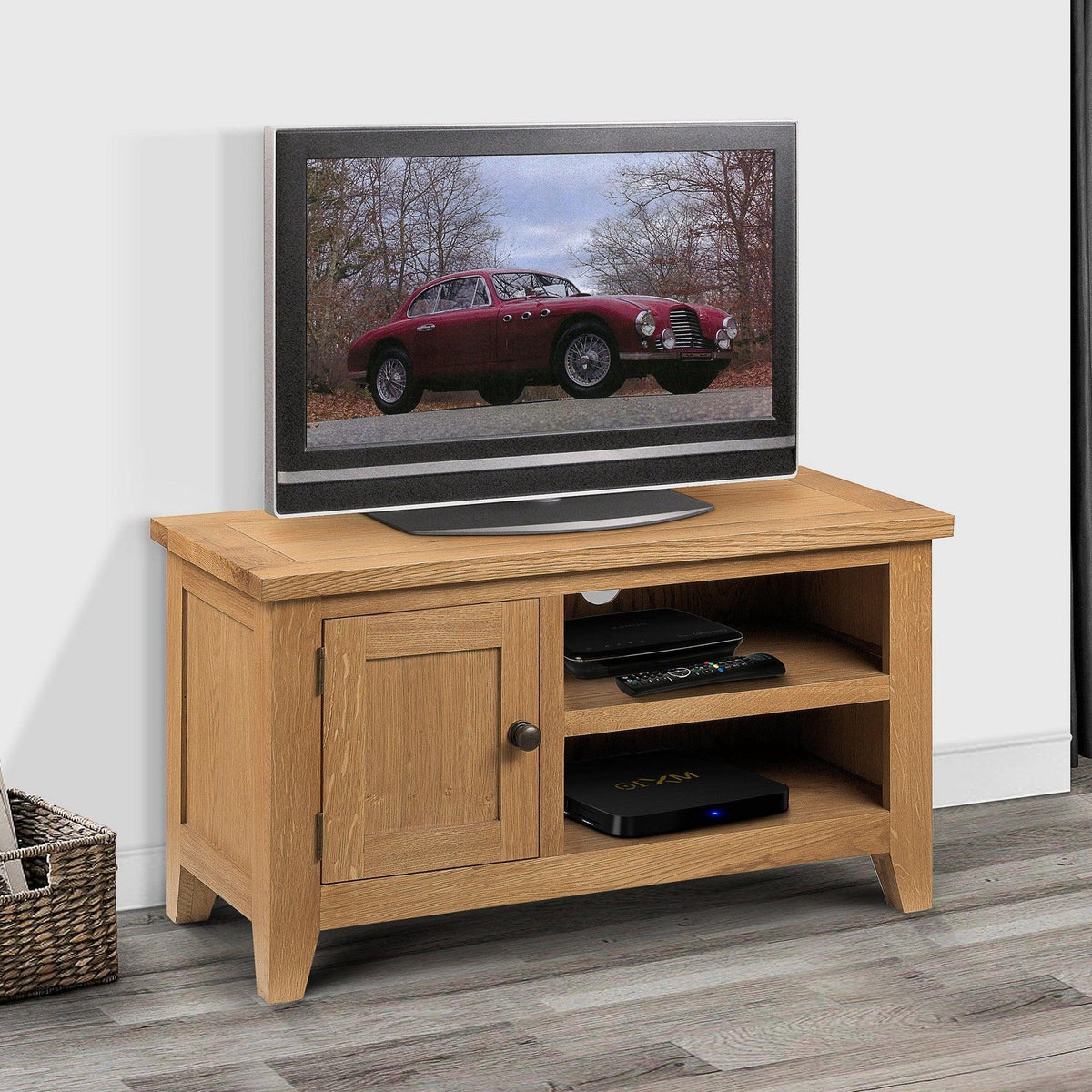 Oak TV unit with storage shelves and cabinet door on wood floor with television on top