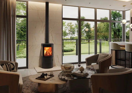 Modern wood burning stove in a stylish living room with large windows and a view of greenery.
