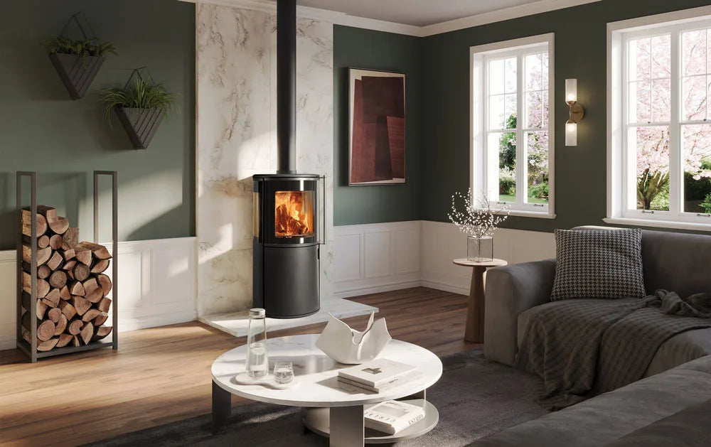 Modern living room featuring an Atlas wood burning stove with a warm fire, surrounded by stylish decor and natural light.