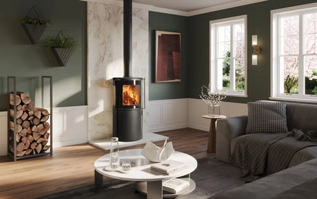 Modern living room featuring an Atlas wood burning stove with a warm fire, surrounded by stylish decor and natural light.