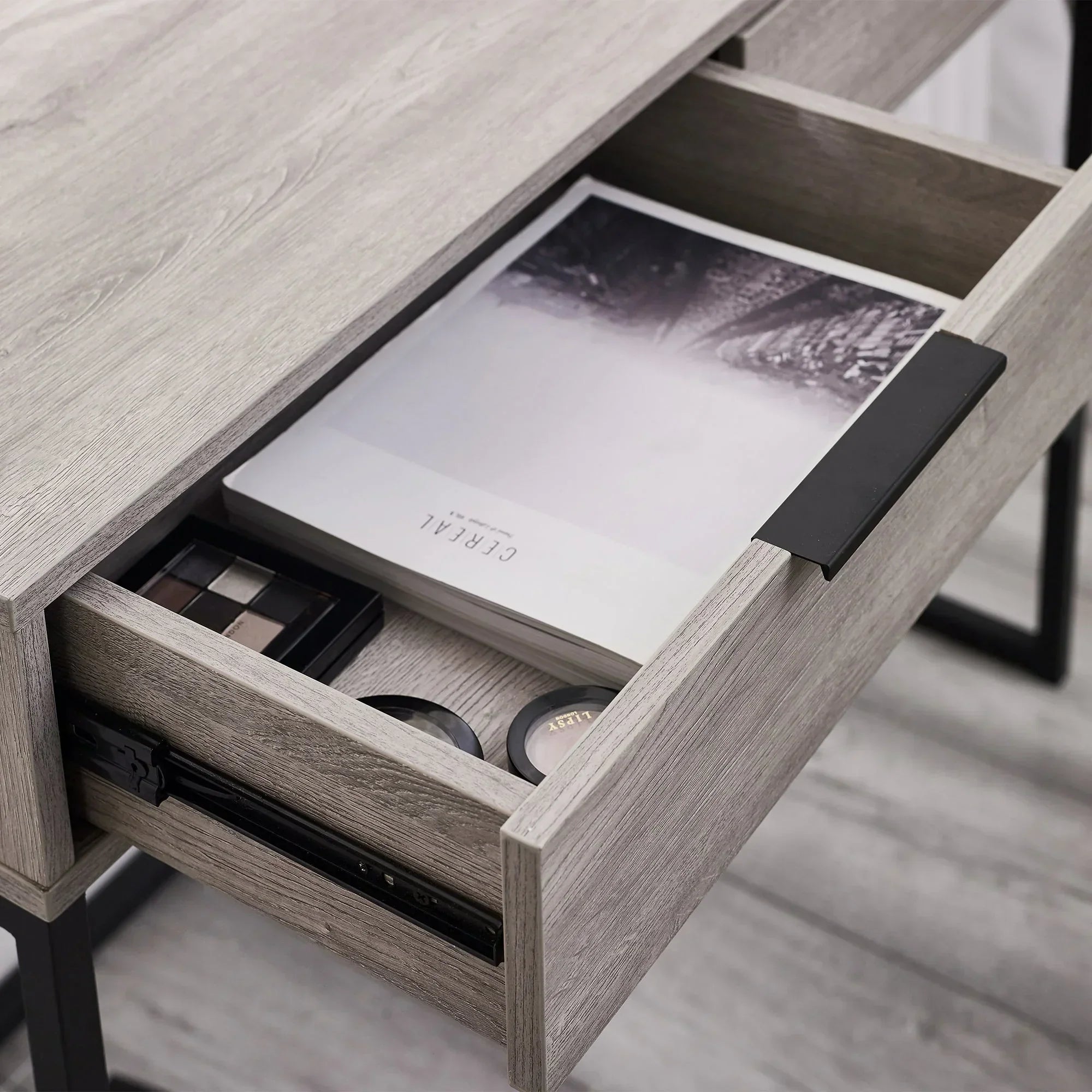 Grey oak dressing table desk drawer with metal handle, open to show organized storage compartments