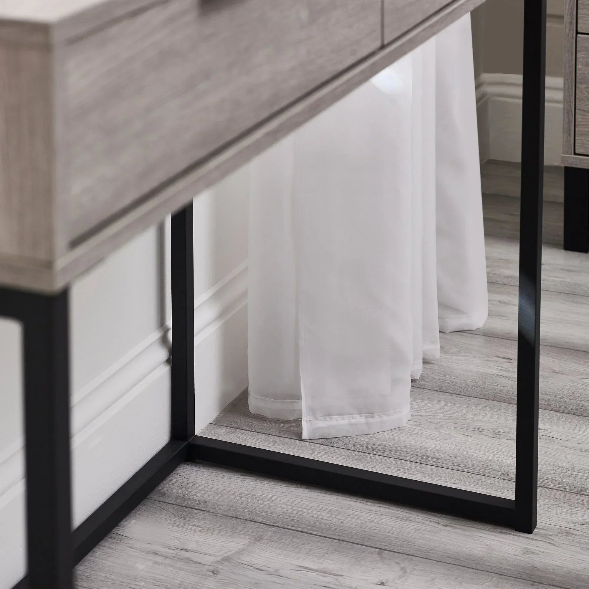 Grey oak dressing table desk with black metal legs close up on wood grain and frame