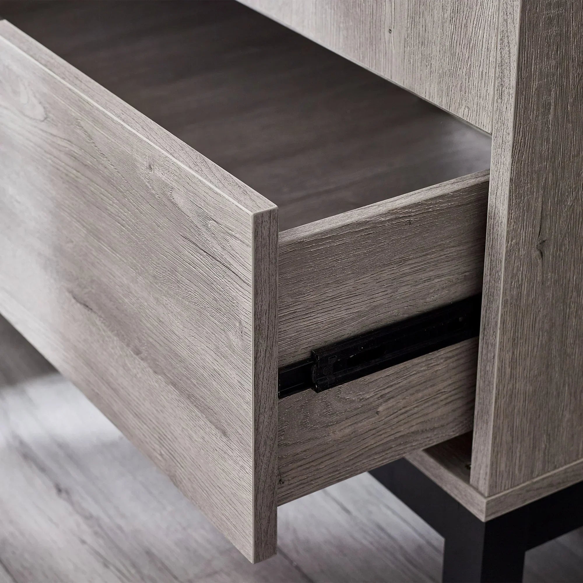 Closeup of Bali wardrobe drawer in grey wood finish showing smooth metal runner detail