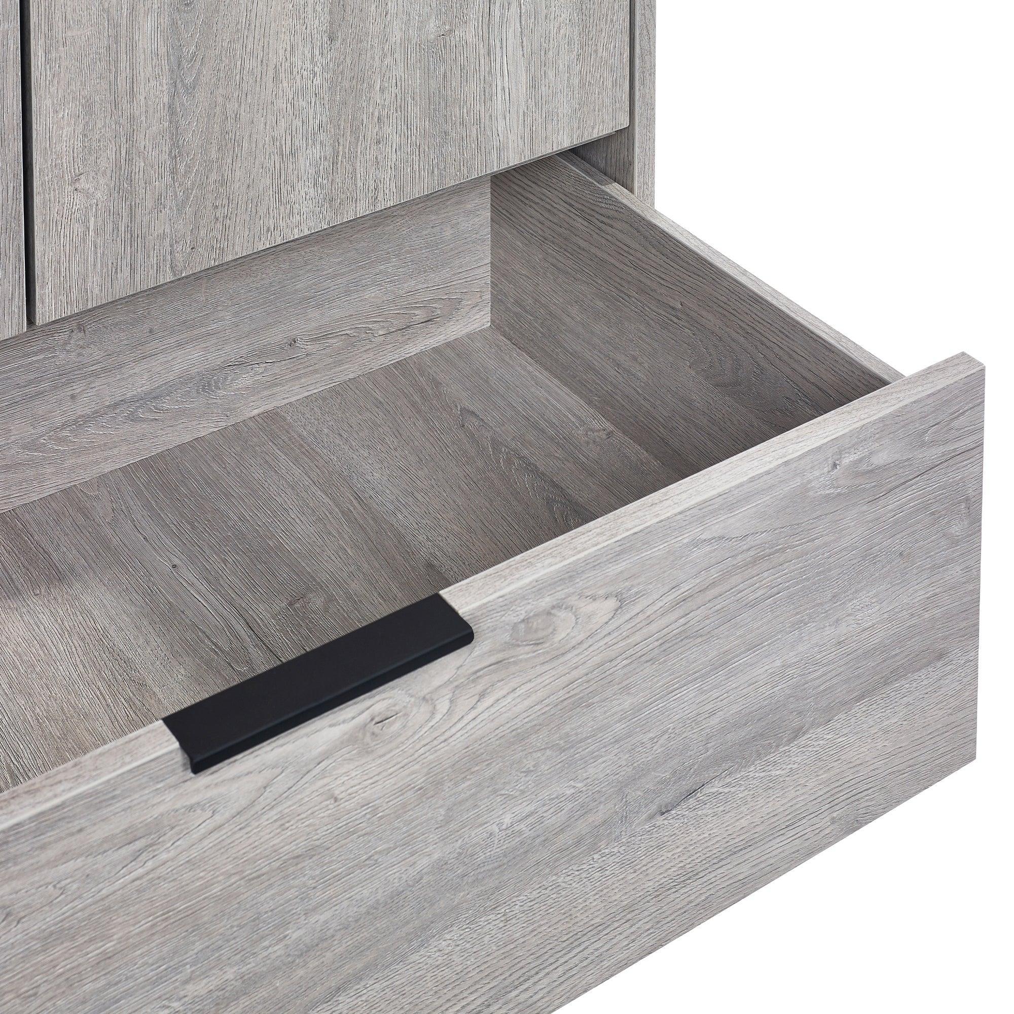 Grey wood wardrobe drawer open showing textured finish and black metal handle