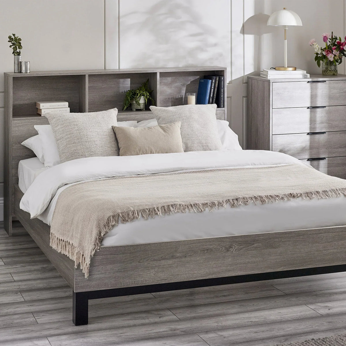 Grey oak bookcase headboard bed with storage, styled with cushions and bedside decor