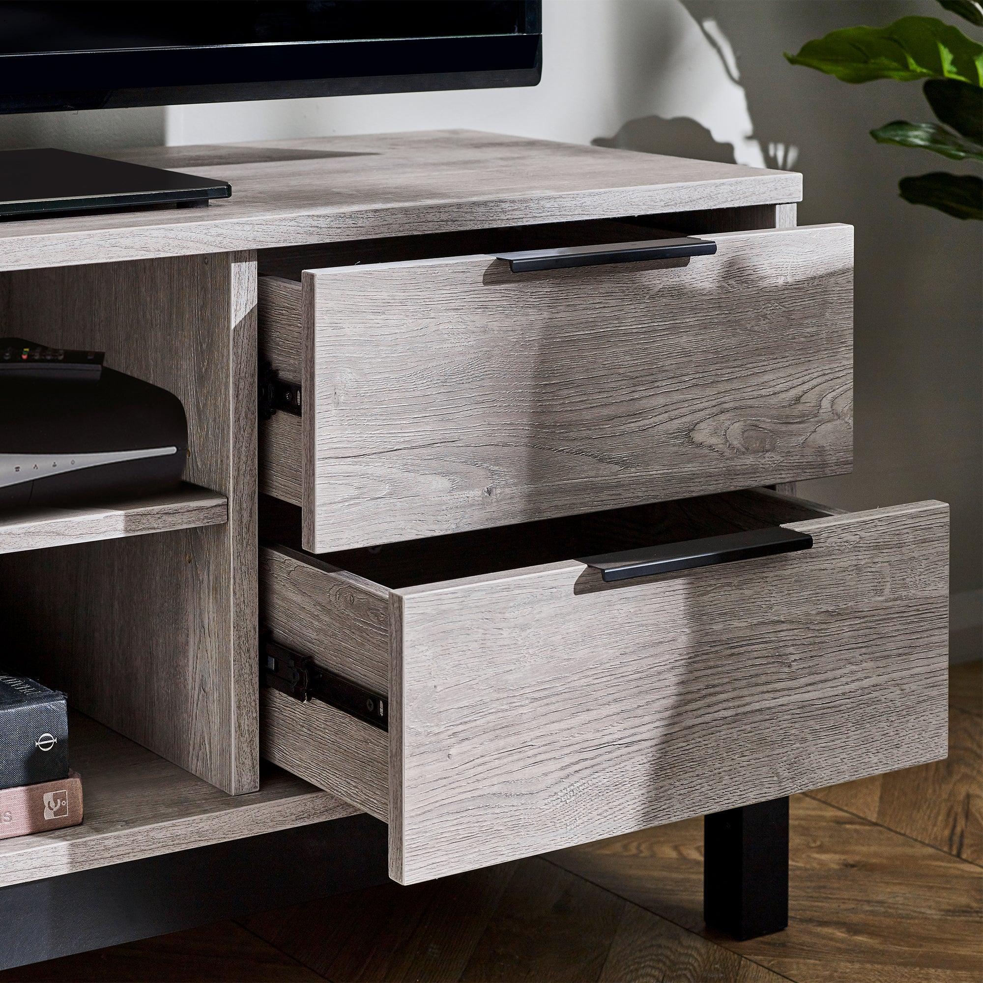 Grey oak TV unit with open drawers, black handles, wood grain finish and shelving detail