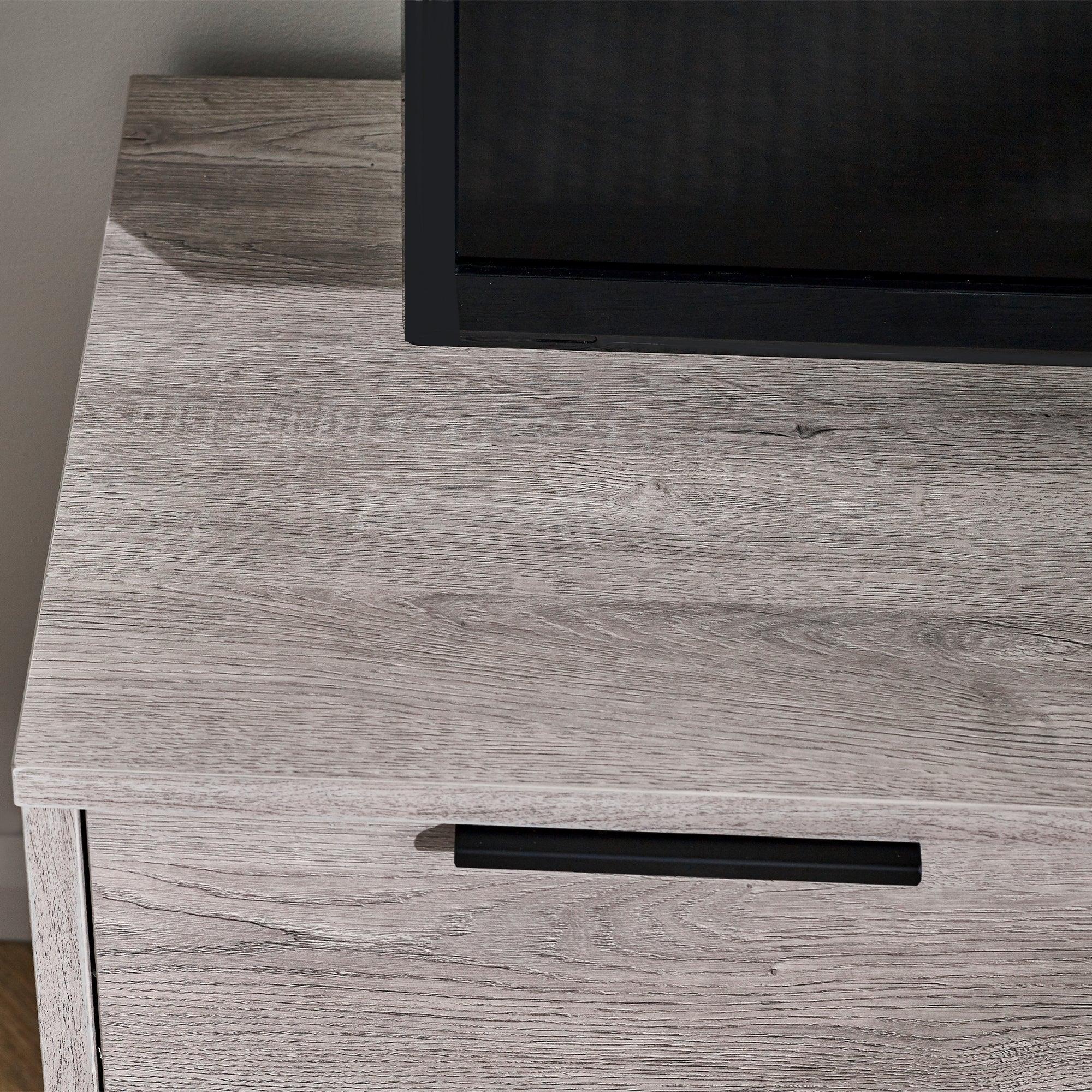 Grey oak TV unit top with wood grain detail and black handle in close-up view