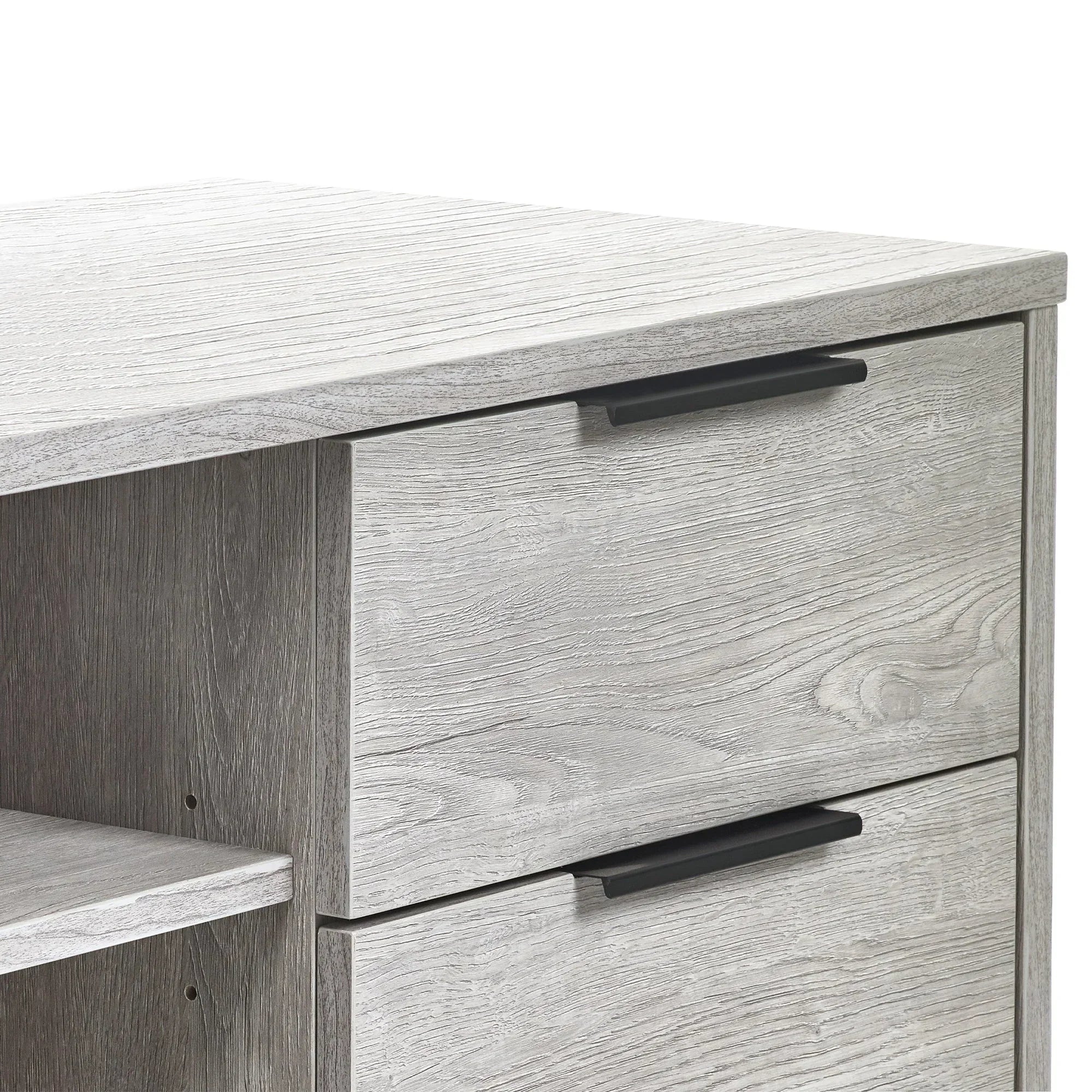 Close-up of grey oak TV unit drawers with black handles and wood grain texture
