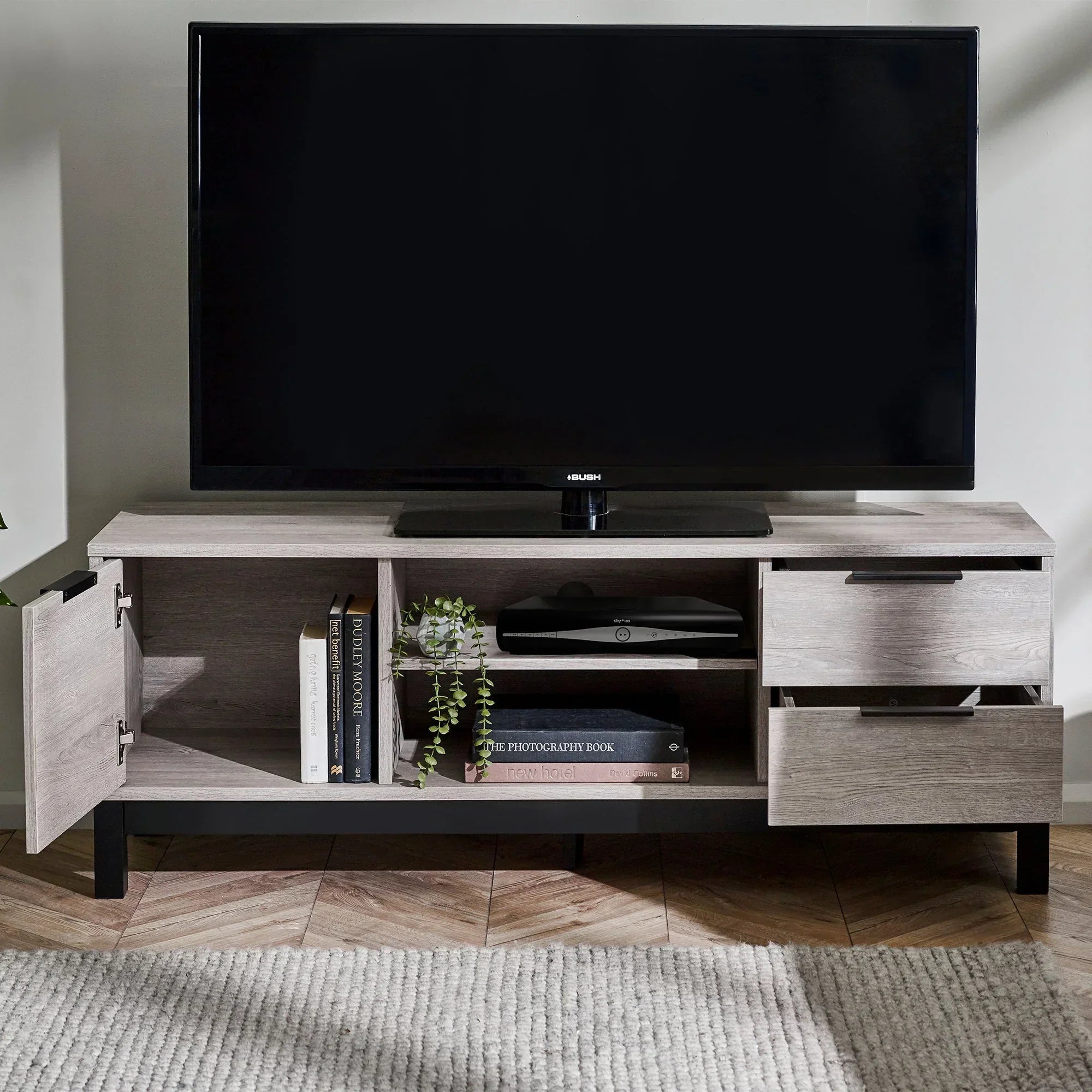 Grey oak TV unit with open shelving, books, side cabinet, and two drawers in living room