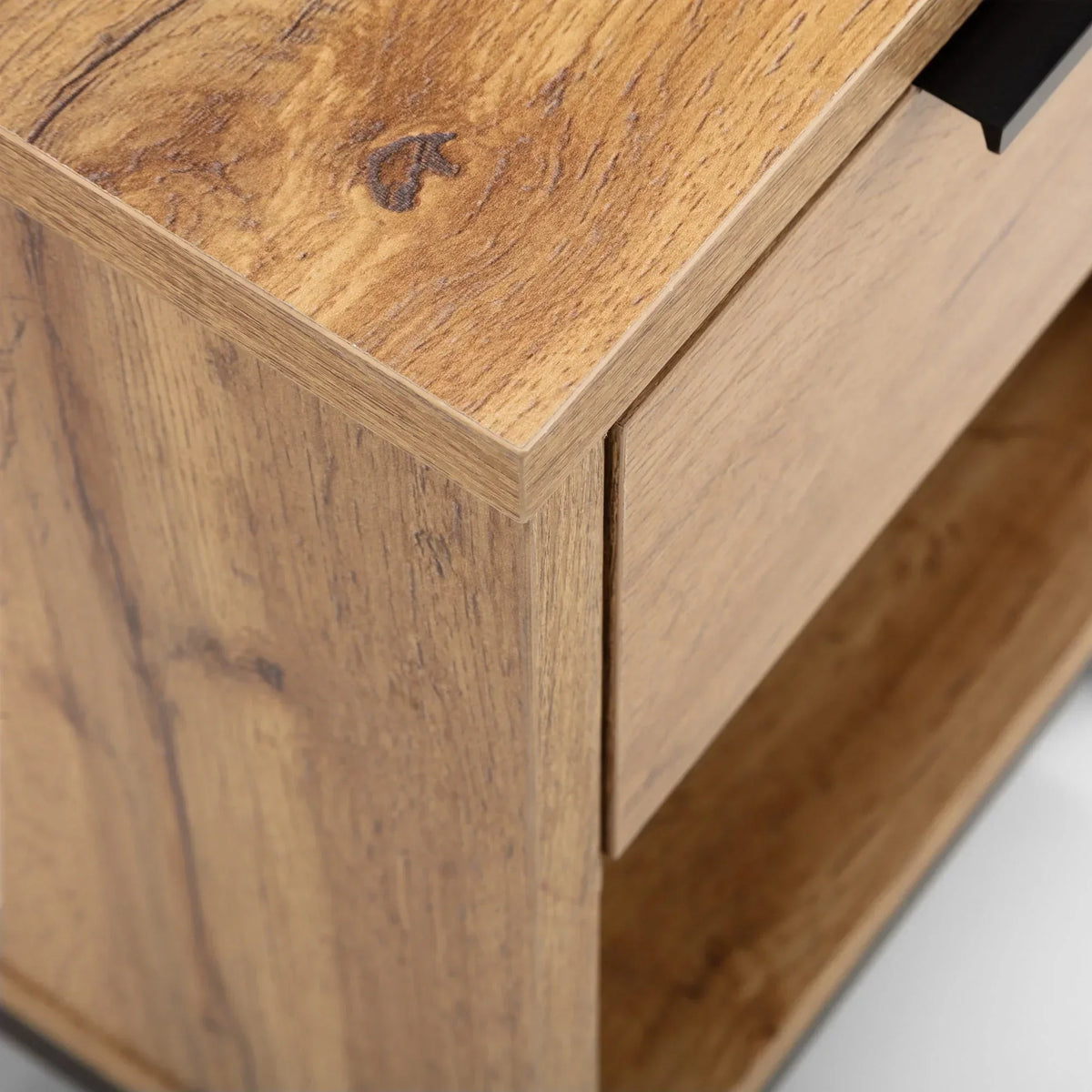 Close-up of wooden bedside table with drawer and black handle