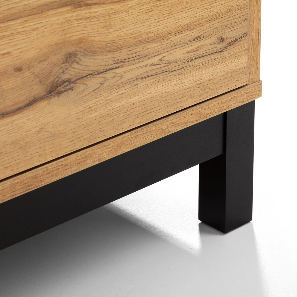 Close-up of wooden chest drawer with black metal leg and oak grain detail