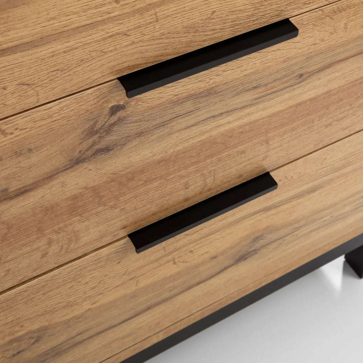 Close-up of Bali 6 drawer chest in light wood with black metal handles and base