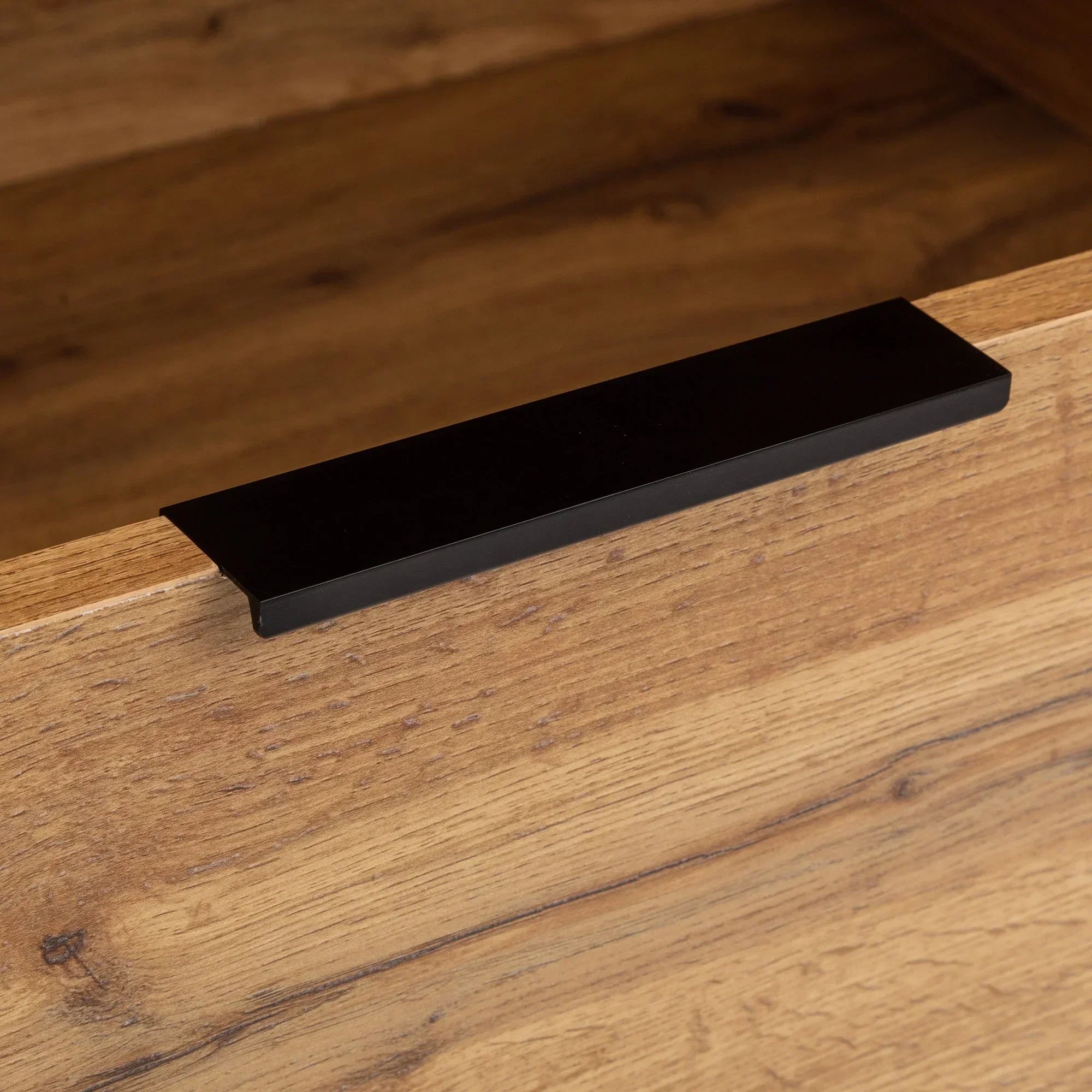 Closeup of wardrobe wood grain and black metal handle detail