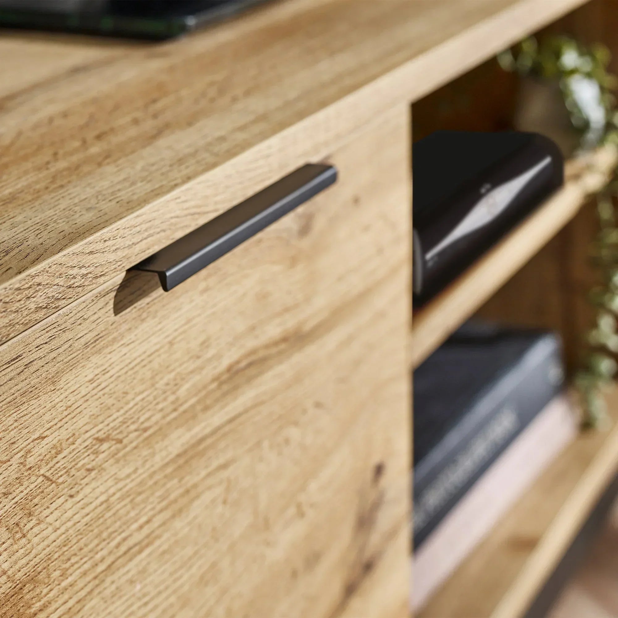 Light oak TV unit detail showing handle and open shelving with decor